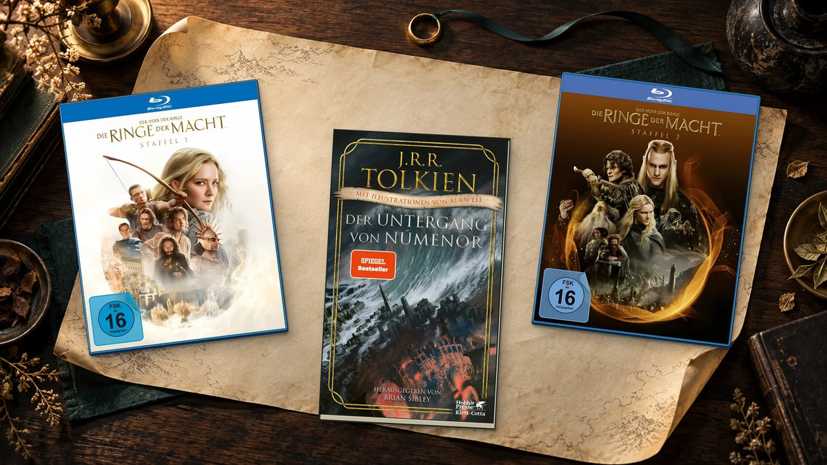 Blu-rays der ersten beiden Staffeln von „Die Ringe der Macht“ und Tolkiens „Der Untergang von Númenor“ auf Pergament neben einem goldenen Ring.