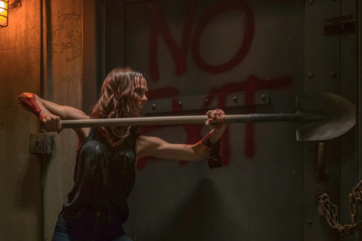 Jigsaw – SAW VIII – Eine Frau hält eine Schaufel vor einer Wand