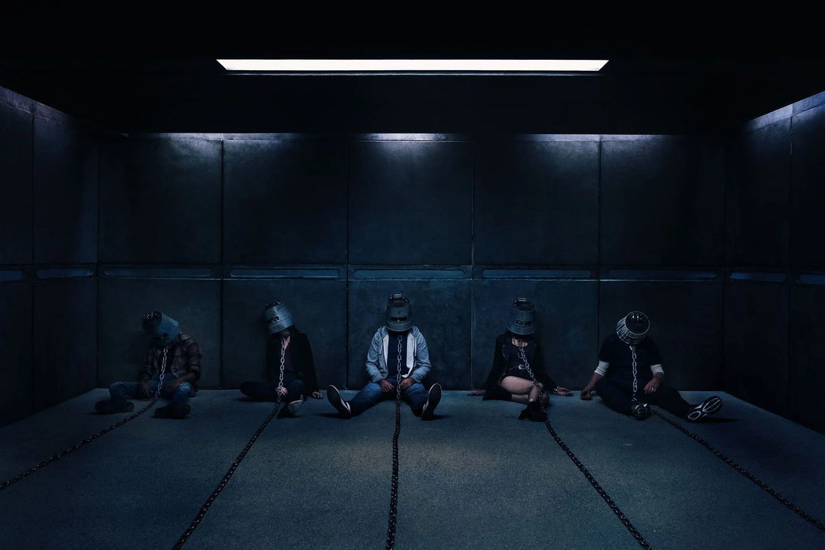 Jigsaw – SAW VIII – Fünf angekettete Personen in einem blau beleuchteten Raum
