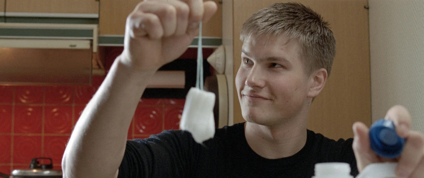 Nord – Ein junger Mann hält die Fäden von Teebeuteln