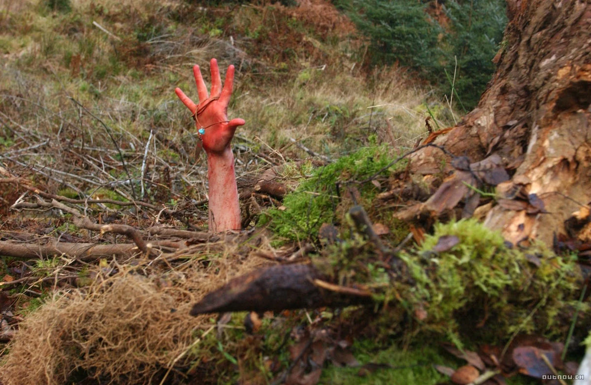 The Descent – Abgrund des Grauens – Eine Hand greift aus einer Öffnung im Waldboden