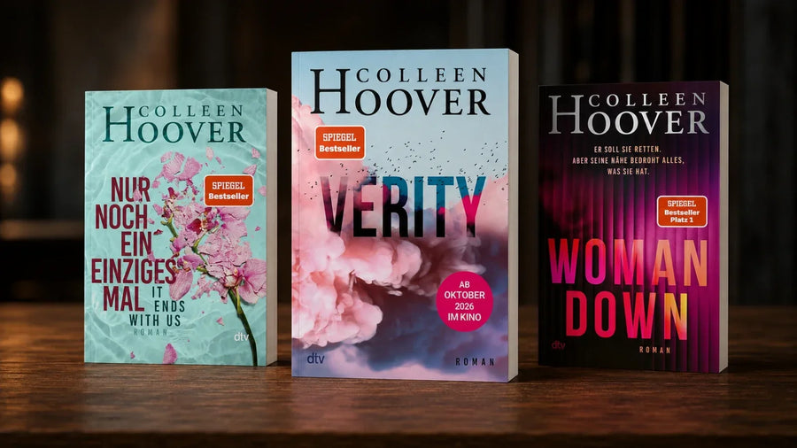 Drei Romane von Colleen Hoover auf einem dunklen Holztisch: Nur noch ein einziges Mal, Verity und Woman Down