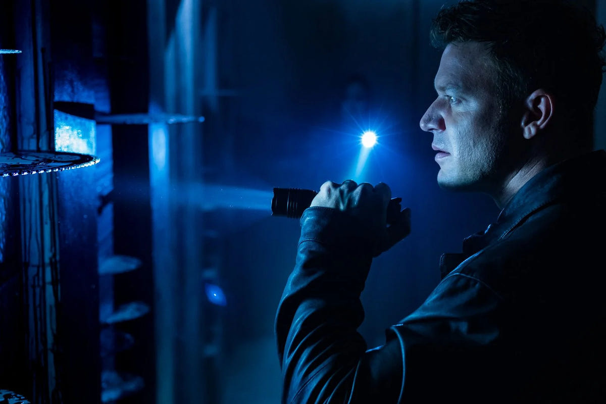 Jigsaw – SAW VIII – Ein Mann mit einer Taschenlampe in einem blauen Raum